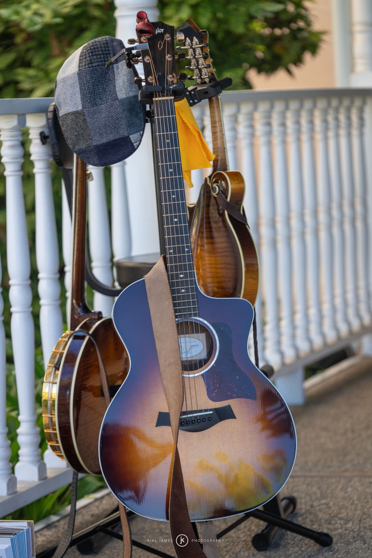 Musicians playing guitars, banjo and mandolin together on a porch